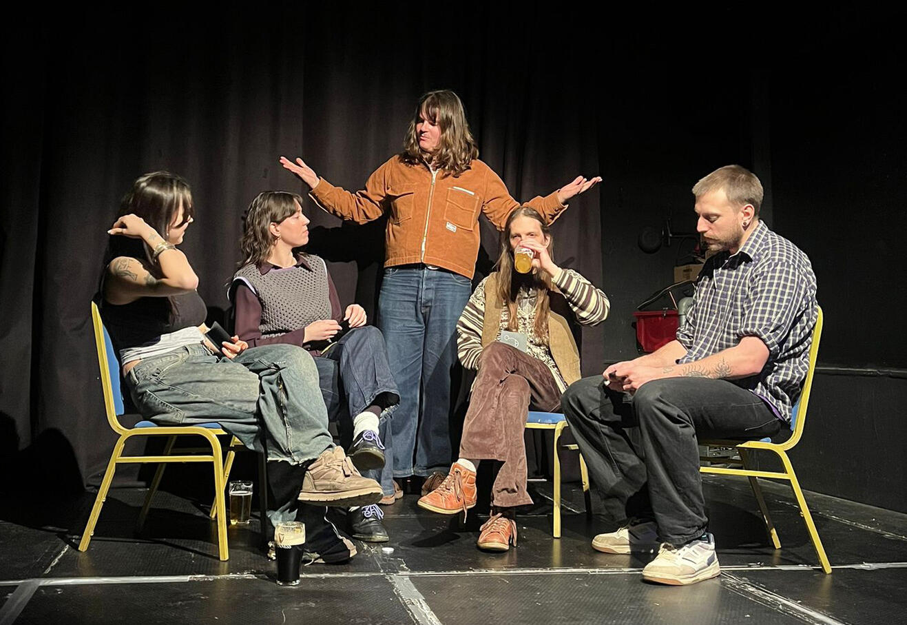 The host, Lewie, on stage with 3 players on chairs around him. This is the final round where Innocents or Traitors will win.